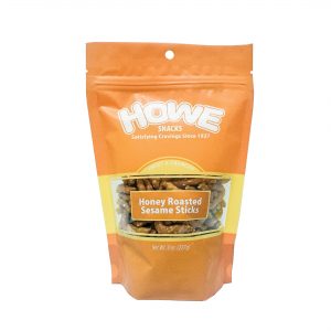 Front view of Howe Snacks Honey Roasted Sesame Sticks bag, in yellowy orange
